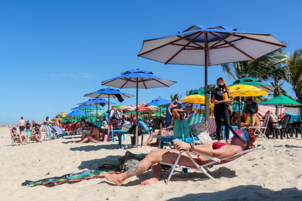 Pessoas tomando sol na Praia do Futuro